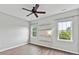 Empty bedroom featuring three windows, hardwood floors, a ceiling fan, and floating shelves at 240 Faust Rd, Davidson, NC 28036
