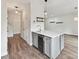 Stylish kitchen island with white countertop, grey cabinets, wine fridge, and hardwood floors at 240 Faust Rd, Davidson, NC 28036