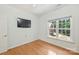 Cozy bedroom with hardwood floors, a large window, and a mounted TV at 3009 Brooks Mill Ln, Wingate, NC 28174