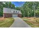Detached brick garage with a long concrete driveway and surrounded by lush greenery and mature trees at 3009 Brooks Mill Ln, Wingate, NC 28174