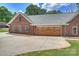 Spacious garage with a concrete driveway and wooden garage doors, complementing the brick home exterior at 3009 Brooks Mill Ln, Wingate, NC 28174