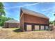 Large detached garage featuring multiple doors with a large grassy area and home in the background at 3009 Brooks Mill Ln, Wingate, NC 28174