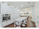 Elegant kitchen featuring custom white cabinets, stainless steel appliances, and an open dining/living area at 3009 Brooks Mill Ln, Wingate, NC 28174