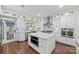 Bright open kitchen featuring white cabinetry, stainless steel appliances and a marble countertop island at 3009 Brooks Mill Ln, Wingate, NC 28174
