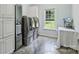 Laundry room with modern front-load washer and dryer, storage cabinets, and large window at 3009 Brooks Mill Ln, Wingate, NC 28174