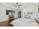 Spacious main bedroom featuring hardwood floors, tray ceiling, ceiling fan, and seating area at 3009 Brooks Mill Ln, Wingate, NC 28174
