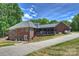 Brick home featuring a covered patio and a well-maintained lawn, creating a cozy outdoor living space at 3009 Brooks Mill Ln, Wingate, NC 28174
