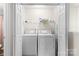 A functional laundry area features a side-by-side washer and dryer, plus organized shelving for supplies at 3030 Priory Ridge Dr, Fort Mill, SC 29707