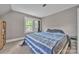 Bright bedroom with neutral walls, blue-and-gray bedding, and a view of the outdoors at 3101 Hickory Hwy, Statesville, NC 28677