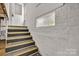 Stairwell leading to door features painted brick, small window, and grey carpeted steps at 3101 Hickory Hwy, Statesville, NC 28677