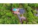 An aerial view of a property featuring a well-maintained pool, stone patio and driveway, nestled among lush trees at 3125 Arden Way, Claremont, NC 28610