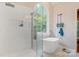 Bright bathroom featuring a soaking tub, glass shower, and a large arched window at 3125 Arden Way, Claremont, NC 28610
