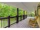 Large covered deck with wooden floors, railing, and a rocking chair at 3125 Arden Way, Claremont, NC 28610