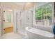 Bright bathroom featuring a glass shower, a modern tub, and a large arched window at 3125 Arden Way, Claremont, NC 28610
