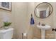 This powder room features textured walls, a pedestal sink, and a round mirror at 3125 Arden Way, Claremont, NC 28610