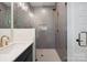 Stylish bathroom featuring a vanity, shower with unique gray tiling, and modern fixtures at 3538 Saker Ln, Charlotte, NC 28211