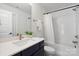 Well-lit bathroom features subway tile, navy vanity, modern fixtures, and a shower-tub combination at 3538 Saker Ln, Charlotte, NC 28211