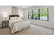 Bedroom with a comfy bed, bedside tables and a window with a view to the deck outside at 3538 Saker Ln, Charlotte, NC 28211