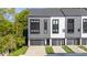 Modern townhome featuring gray and white siding, black trim, and a private garage and driveway at 3538 Saker Ln, Charlotte, NC 28211