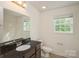Bright bathroom features a dark granite vanity, tile floors, and a framed mirror at 4015 Amber Leigh Way Dr, Charlotte, NC 28269