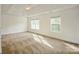 Spacious primary bedroom featuring a tray ceiling, neutral carpet, and bright natural light from two large windows at 4015 Amber Leigh Way Dr, Charlotte, NC 28269