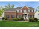 Charming two-story red brick home with black shutters, manicured lawn, and inviting front porch at 4015 Amber Leigh Way Dr, Charlotte, NC 28269
