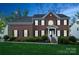 Traditional brick home with manicured lawn and welcoming entrance at dusk at 4015 Amber Leigh Way Dr, Charlotte, NC 28269