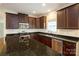 A well-lit kitchen featuring granite countertops, stainless steel appliances, and dark wood cabinetry at 4015 Amber Leigh Way Dr, Charlotte, NC 28269