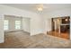 Open living room featuring neutral carpet, bright natural light, and entry to dining and kitchen at 4015 Amber Leigh Way Dr, Charlotte, NC 28269
