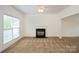 Spacious living room featuring neutral carpet, a fireplace, and abundant natural light from a large window at 4015 Amber Leigh Way Dr, Charlotte, NC 28269