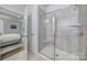 Modern bathroom featuring a glass enclosed shower with tile surround and a view into the main bedroom at 5101 Helmsworth Dr, Waxhaw, NC 28173