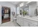 Elegant bathroom featuring a double vanity, large mirror, and a walk-in closet with custom shelving at 5101 Helmsworth Dr, Waxhaw, NC 28173