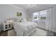 Bright bedroom with a large window, white bedding, and minimalist decor creating a cozy retreat at 5101 Helmsworth Dr, Waxhaw, NC 28173