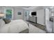 Bright main bedroom showcasing wood-look floors, large windows, and a modern dresser with a mounted TV at 5101 Helmsworth Dr, Waxhaw, NC 28173