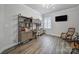 Office with a built-in desk and rocking chairs, hardwood floors, and a wall mounted TV at 5101 Helmsworth Dr, Waxhaw, NC 28173