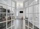 View of the bright office through glass doors, highlighting its built-in shelves, desk, and cozy seating at 5101 Helmsworth Dr, Waxhaw, NC 28173