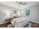 Light bedroom with decorative pillows, white linens, and hardwood floor at 513 Inwood Dr, Charlotte, NC 28209