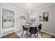 Bright dining room with modern lighting fixture, adjacent to a kitchen with white cabinets at 513 Inwood Dr, Charlotte, NC 28209