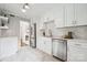 Modern white kitchen with stainless steel appliances, herringbone backsplash, and tile flooring at 513 Inwood Dr, Charlotte, NC 28209