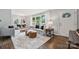 Inviting living room featuring hardwood floors, large windows, and modern furniture with an open floor plan at 513 Inwood Dr, Charlotte, NC 28209