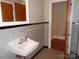 Bathroom with a modern sink, tiled walls, and a door leading to additional rooms at 5209 Markay St, Matthews, NC 28105