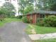 Charming brick home with a well-maintained lawn, mature trees, and an asphalt driveway at 5209 Markay St, Matthews, NC 28105