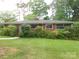 A traditional single-story brick home featuring well-maintained landscaping at 5209 Markay St, Matthews, NC 28105