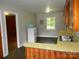 Cozy kitchen with retro refrigerator, wooden cabinets, and a stainless steel sink overlooking greenery at 5209 Markay St, Matthews, NC 28105