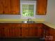 Traditional kitchen with wooden cabinets, a stainless steel sink, and a window overlooking greenery at 5209 Markay St, Matthews, NC 28105
