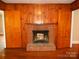 Living room featuring a brick fireplace flanked by wooden-paneled walls and built-in closet space at 5209 Markay St, Matthews, NC 28105