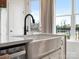 Farmhouse kitchen sink with modern faucet, stainless dishwasher, and bright natural light at 5644 Kingspan Dr, Charlotte, NC 28217