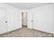 A bedroom with neutral carpet leading to a bathroom with a walk-in closet at 624 W Kerr St, Salisbury, NC 28144