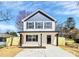New construction two-story home with gray and white color scheme, black shutters, a covered front porch, and newly seeded lawn at 624 W Kerr St, Salisbury, NC 28144