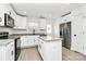 Bright kitchen has white cabinets, an island, stainless appliances, granite countertops, and a door to the backyard at 624 W Kerr St, Salisbury, NC 28144